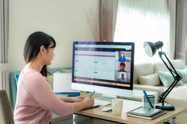 A women works remotely at an online meeting